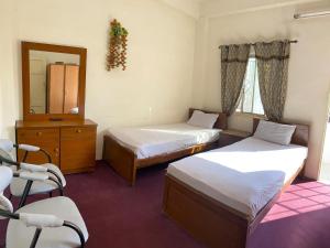 伊斯兰堡Stay Inn Islamabad的客房设有两张床、梳妆台和镜子。