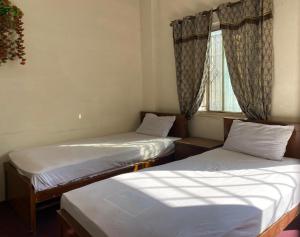 伊斯兰堡Stay Inn Islamabad的带窗户的客房内的两张床