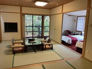 屋久岛绳文之宿蔓藤酒店的一间带桌椅的房间和一间卧室