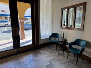 索诺拉索诺拉历史旅馆的一间设有两把椅子和一张桌子的房间,窗户