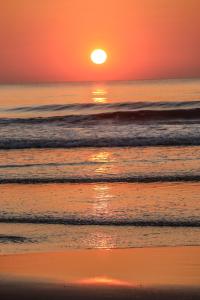 戈卡尔纳Blue Lagoon Redefined的海面上洋的橙色日落,海浪
