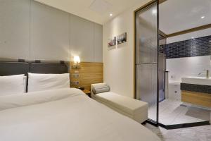 釜山Hotel Brooks Busan Gijang的一间卧室配有一张床、淋浴和盥洗盆