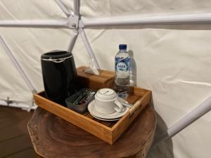 库布Glamping @ Pebbles & Fins的一张带桌子上一瓶水的木制托盘