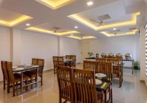 尼杜巴塞莱Airport Avenue Plaza Cochin Airport的用餐室配有木桌和椅子