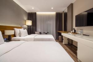 阿塔库姆Elite World Comfy Samsun Atakum的酒店客房配有两张床和一张书桌