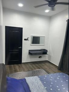 亚娄Dya@Nas Homestay Arau的卧室配有一张床,墙上配有电视。