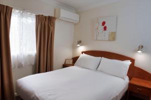 肯图巴肯图巴大都会宾馆的卧室配有白色的床和窗户。