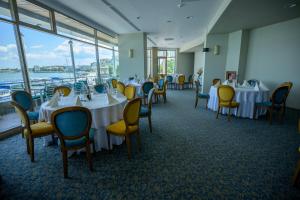 图尔恰埃斯普拉纳达酒店的用餐室配有白色的桌子和黄色的椅子