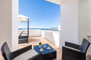 马贝拉Dúplex de Lujo Marbella Golf的阳台配有桌椅,享有海景。