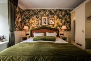 哥德堡皮加勒酒店的一间卧室配有一张带绿毯的大床