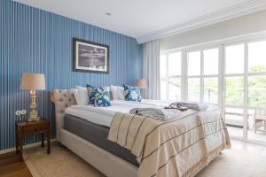 斯塔德斯塔德索尔特希尔贝德酒店的一间卧室配有一张带蓝色墙壁的大床