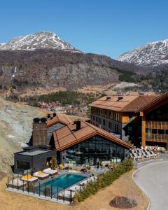 海姆瑟达尔Fýri Resort的一座带游泳池和山脉的度假村