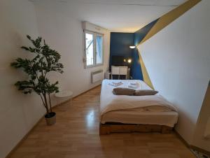 米卢斯Ton Petit Studio - Le 62 - Coeur de Ville的一间卧室配有一张床和盆栽植物