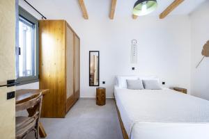 卡尔扎迈纳ANGONI SUITES的卧室配有白色的床和窗户。