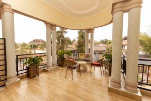 基加利INGANZO BOUTIQUE HOTEL的设有一个配有桌椅并享有美景的阳台。