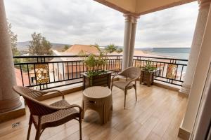 基加利INGANZO BOUTIQUE HOTEL的阳台配有桌椅,享有海景。