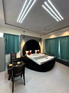 苏拉特Hotel sky palace的一间卧室配有一张大床和一张桌子及椅子