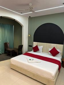 苏拉特Hotel sky palace的一间卧室配有一张带红色枕头的大床