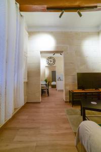 瓦莱塔Valletta Collection - Felix Apartments的走廊上设有带桌子和时钟的客厅