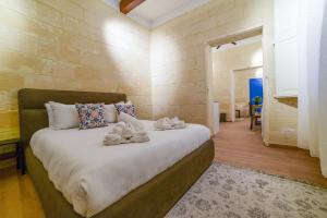 瓦莱塔Valletta Collection - Felix Apartments的一间卧室配有一张大床和毛巾