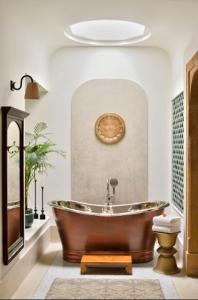 斋沙默尔苏尔亚加酒店的一间带铜浴缸和卫生间的浴室