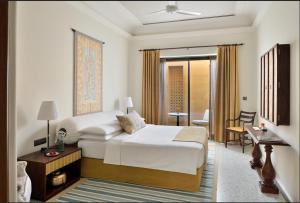 斋沙默尔苏尔亚加酒店的一间卧室配有一张床,另一间卧室配有书桌