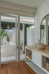 坎古Villa Kelapa Putih - Spacious 4-bedroom Villa with pool PERFECT LOCATION的带浴缸、水槽和镜子的浴室