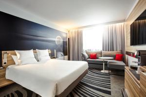 里摩日里摩日湖诺富特酒店的酒店客房设有一张大床和一张沙发。