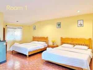 苏安庞The Golden View Resort สวนผึ้ง的黄色墙壁客房的两张床