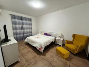 丘达德马拉波APARTMENTO LUMINOSO的一间卧室配有一张床和一张黄色椅子