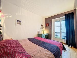 巴黎Bijou de la Corderie - Hyper Central & Spacieux - Les Frères de la Loc'的一间卧室设有一张大床和一个窗户。