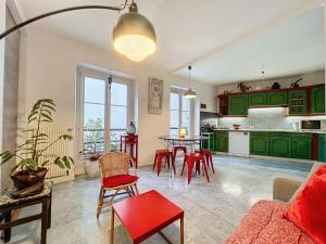 巴黎Bijou de la Corderie - Hyper Central & Spacieux - Les Frères de la Loc'的厨房配有绿色橱柜和红色椅子的桌子
