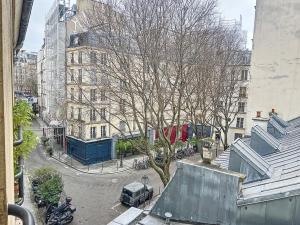 巴黎Bijou de la Corderie - Hyper Central & Spacieux - Les Frères de la Loc'的街道中间的树,有建筑物
