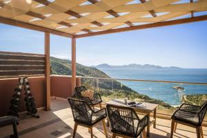 费斯卡尔德宏Entheos Private Villa Fiskardo Kefalonia Greece的阳台配有桌椅,享有海景。