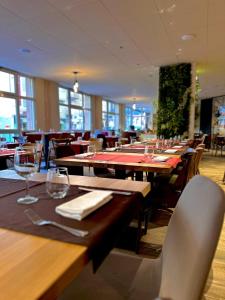 科特雷Garden & City Cauterets Balneo的用餐室配有木桌、椅子和酒杯