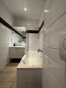 洛克里斯蒂Arriate Hotel的白色的浴室设有浴缸和水槽。