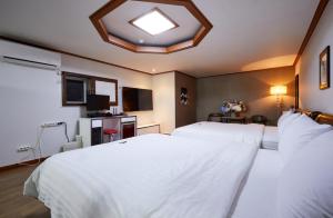 扶安Buantreehotel Blackhouse的卧室设有一张白色大床和天花板
