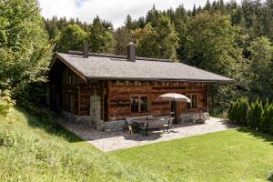 埃尔毛Wochenbrunner Chalets的小木屋配有野餐桌和雨伞