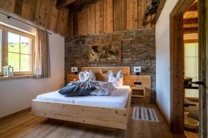 埃尔毛Wochenbrunner Chalets的一间卧室设有一张床和砖墙