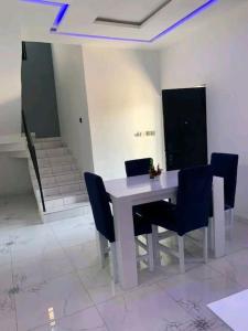 BaguidaBelle villa neuve meublée à Baguida的客房内的白色桌子和蓝色椅子