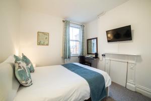 牛津OYO Lonsdale Guest House的卧室配有一张床,墙上配有电视。