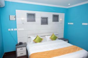 KottakkalHamsted的一间卧室配有一张蓝色墙壁的床