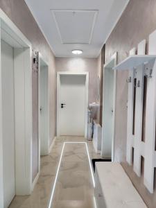 Къща за гости Vip House的走廊设有白色门,铺有瓷砖地板