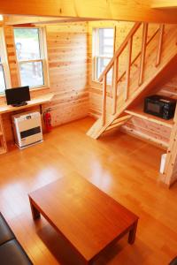 ShōgahoraHirugano Kogen Cottage Park Shikinosato - Vacation STAY 23984v的小木屋内带桌子的客厅