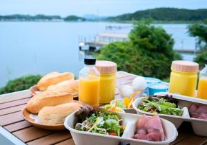 出云市Glamping Base IZUMO "Lakeside Hot Spring Hotel Kun - Vacation STAY 42019v的一张桌子,上面放有食物和橙汁