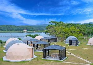 出云市Glamping Base IZUMO "Lakeside Hot Spring Hotel Kun - Vacation STAY 42019v的一群帐篷位于湖边的田野