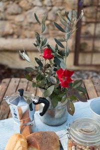 维罗纳Ca' del Buso的一张带红花和面包的花瓶的桌子