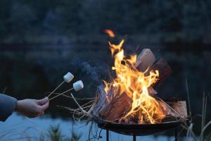 中津川市Hoko Glamping- Camp - Vacation STAY 51101v的一个人在火上烧棉花糖