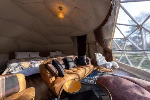 中津川市Hoko Glamping- Camp - Vacation STAY 51101v的一间配有沙发的房间和一张位于帐篷内的床铺