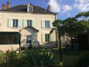 莫讷Grande maison #6 chambres #Proche Amboise/Tours的庭院内有绿色百叶窗和椅子的房子